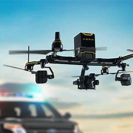 Robuste Technologie-Drohne im Einsatz über Polizeifahrzeug – symbolisiert Schutz bei Absturz, technischen Schäden und Diebstahl.